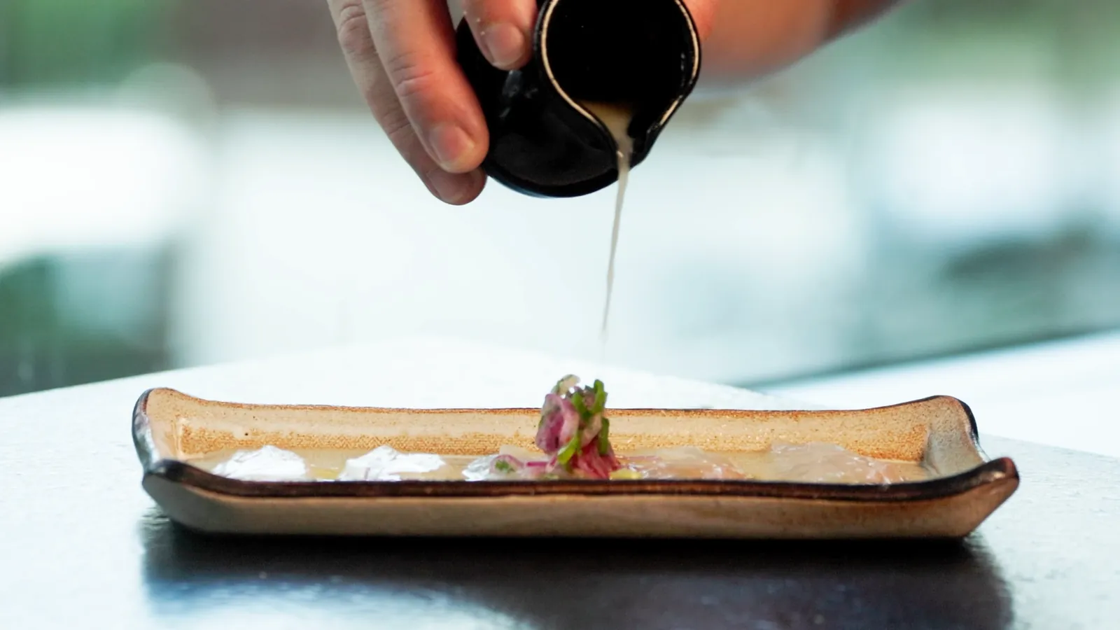 Molho sendo finalizado sobre o prato no Nagairô Sushi — ORB Audiovisual