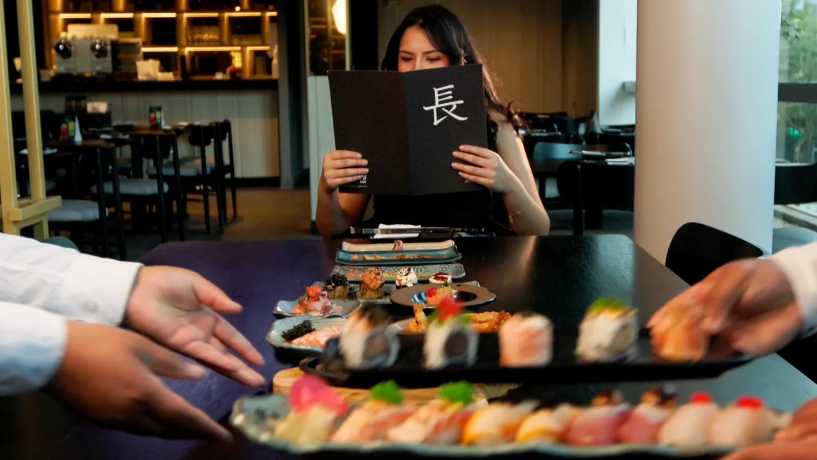 Garçom serve a travessa de sushi à mesa no Nagairô Sushi — ORB Audiovisual